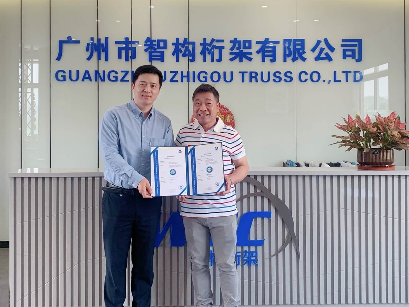 TÜV南德轻工产品部经理郭良亚先生（左）为广州智构总经理蒋伟洪先生（右）颁发TÜV SÜD Mark证书
